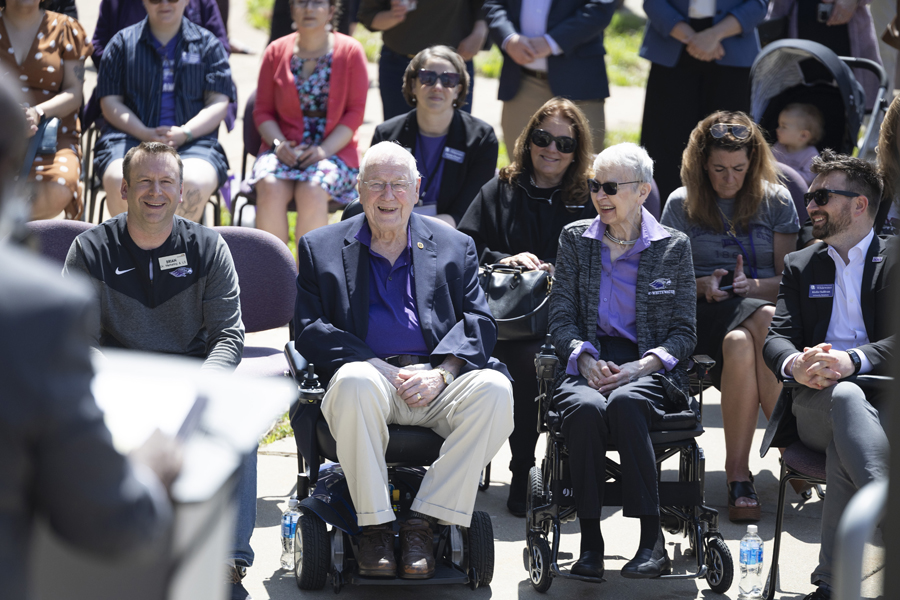 Four people enjoy a laugh as Chancellor Corey A. King speaks at the podium outside.