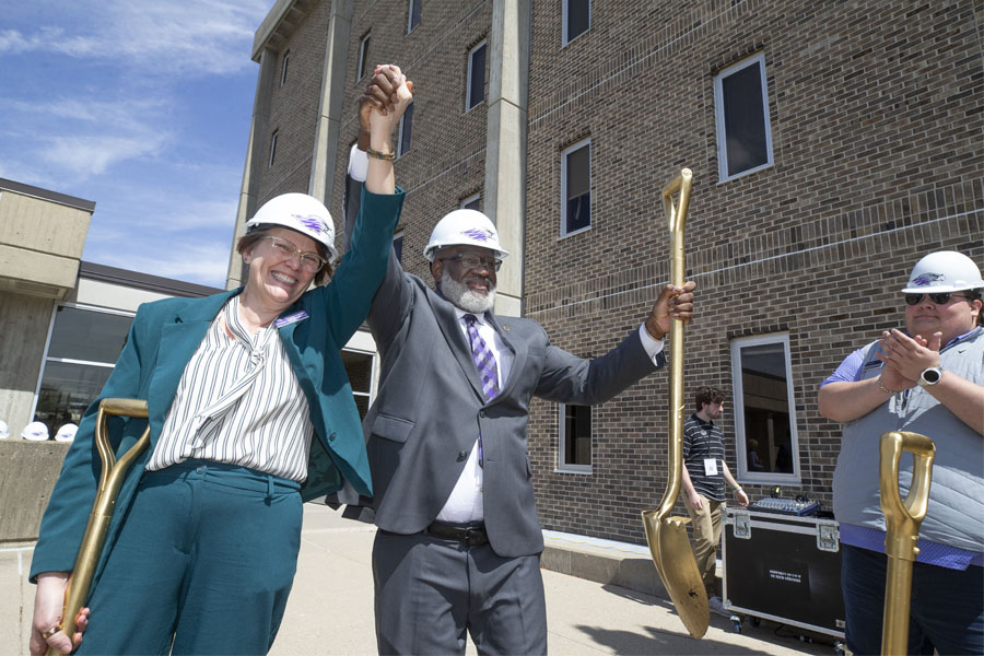 Lana Collet-Klingenberg and Chancellor Corey A. King hold their hands up as person claps in celebration.
