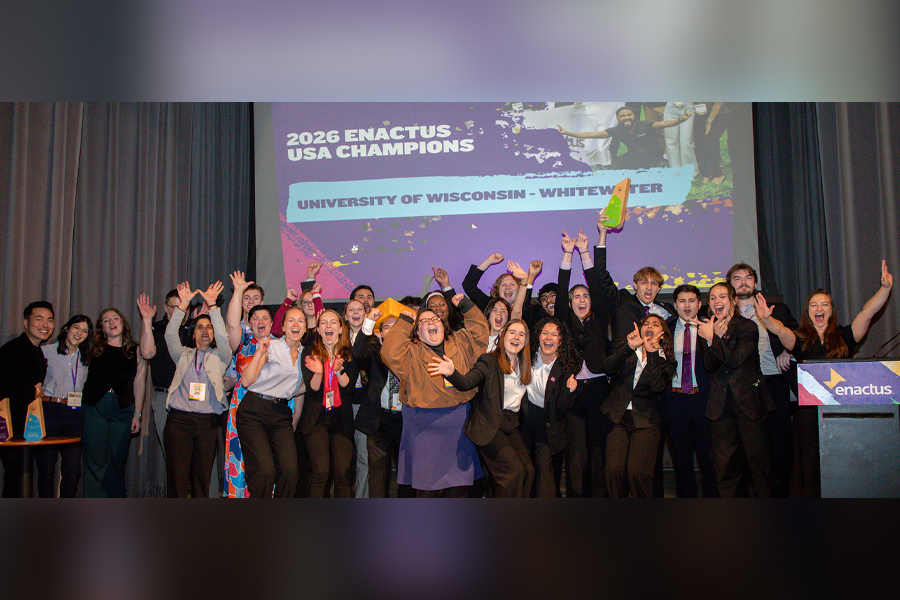 A group of people stand together with their arms raised in celebration.
