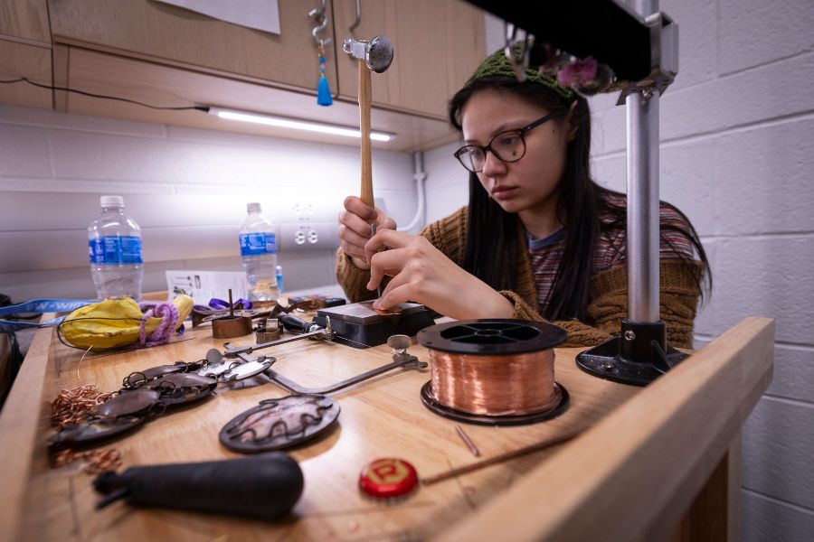Student does artwork with jewelry.