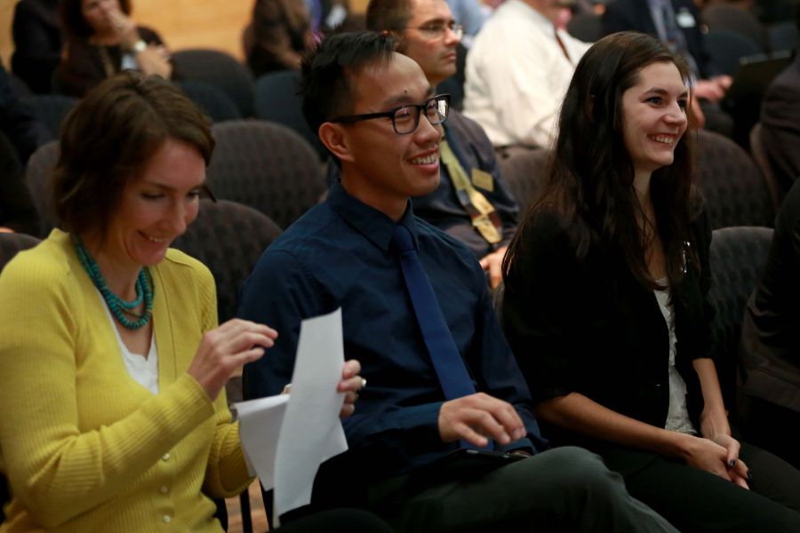 Several students smile while sitting.