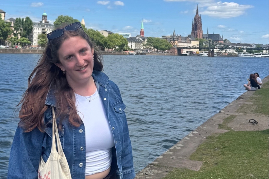 Photo of Emily Coughlin posing next to a landscape. 