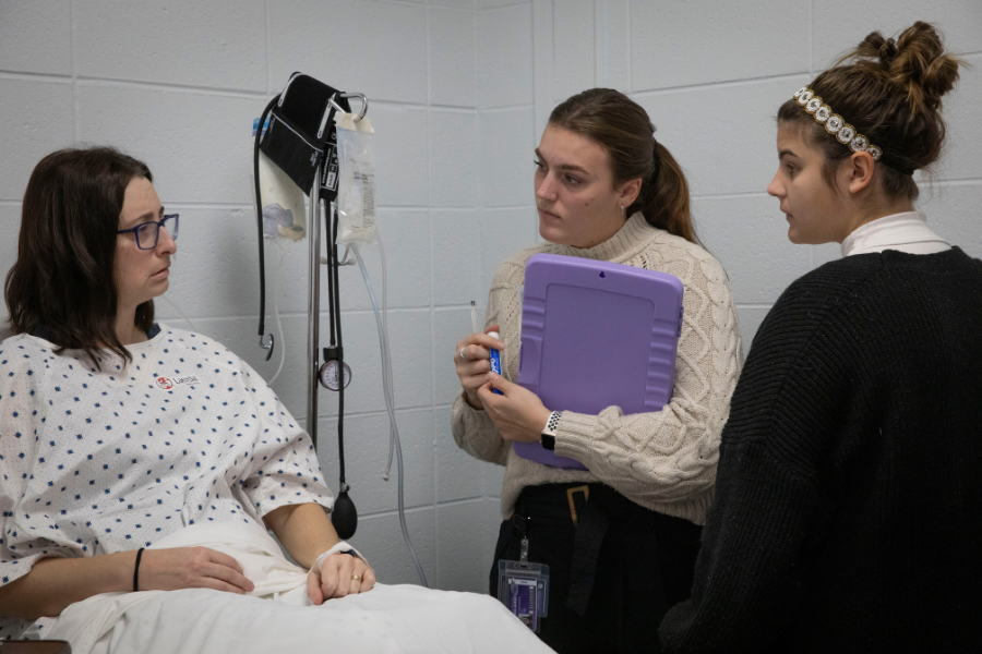 Students working with staff member dressed as patient.