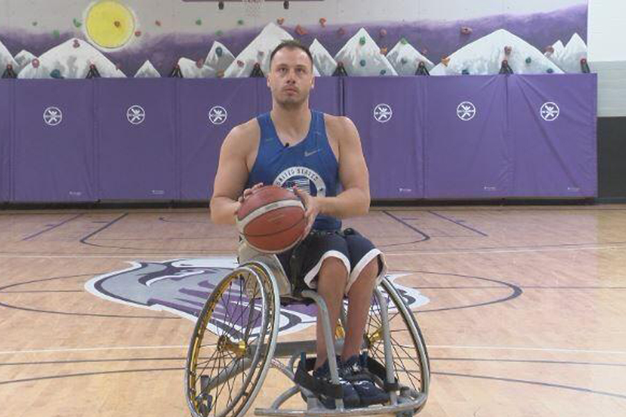 Jake Williams in his wheelchair on the court holding a basketball