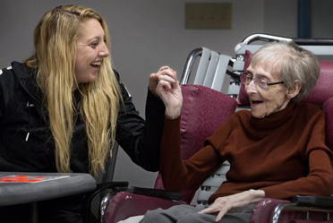 Two community members laughing and holding hands