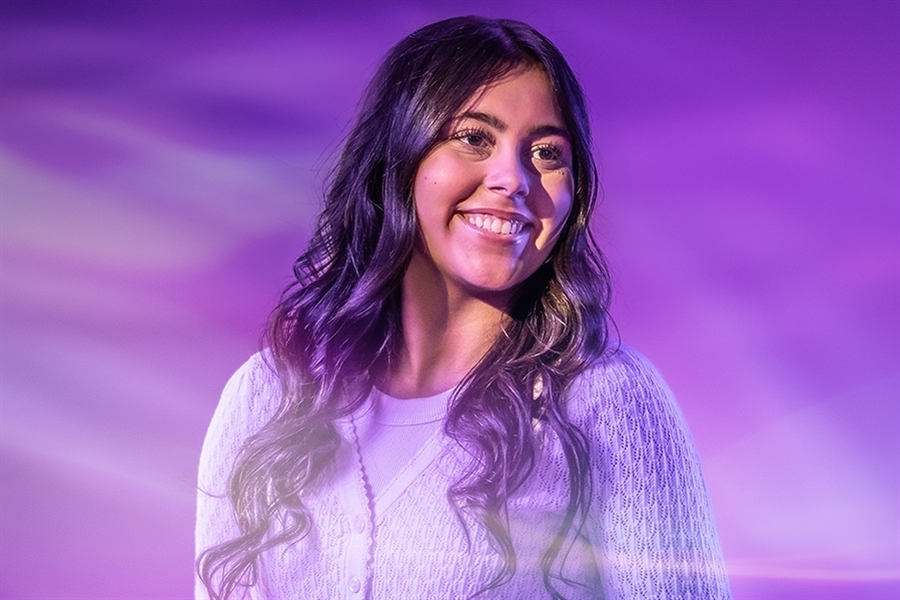 Student with laptop poses for UW-Whitewater College of Business and Economics online 