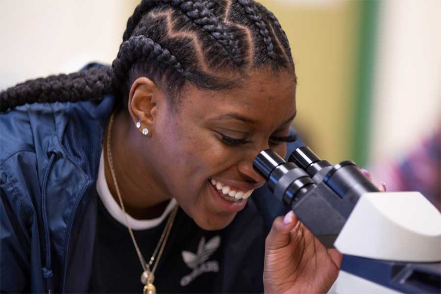 A student looking through a microscope