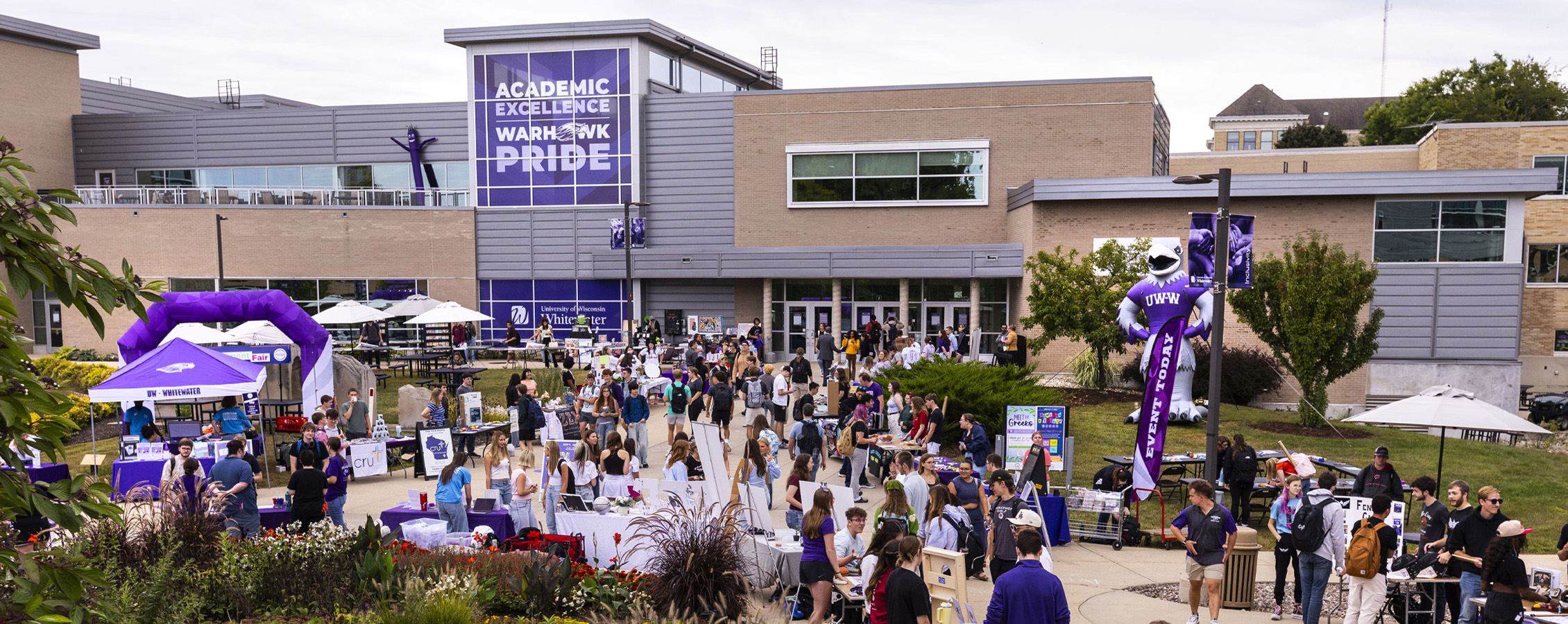 Students fill the sidewalk outside of the university center.