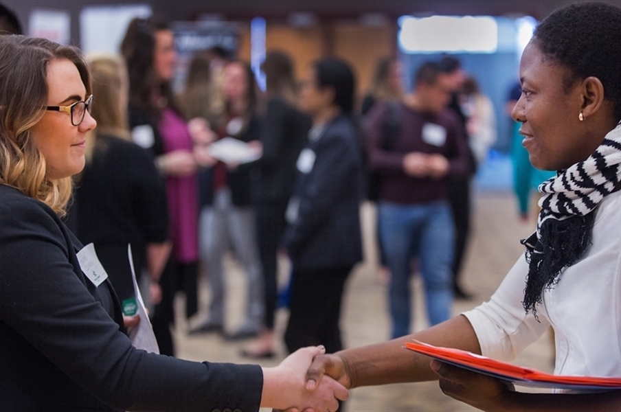 Two people shaking hands at the Hawk Career Fair.