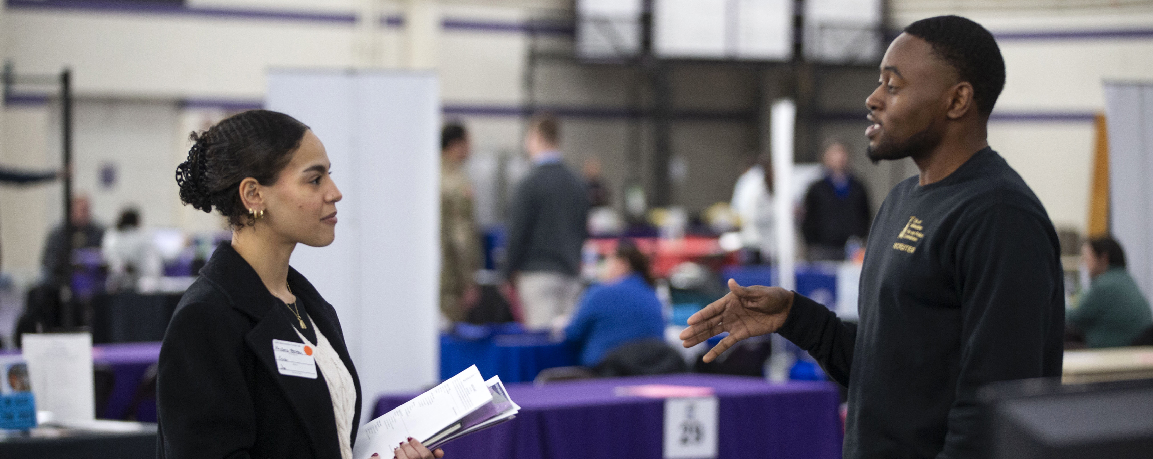 Two people dressed in business attire have a conversation.
