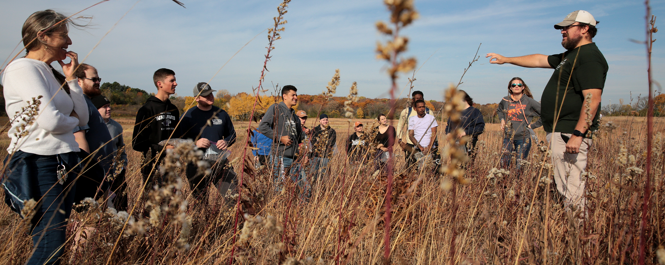 A staff member gives a professor and class a tour of the prairie in the UW-Whitewater Nature Preserve.