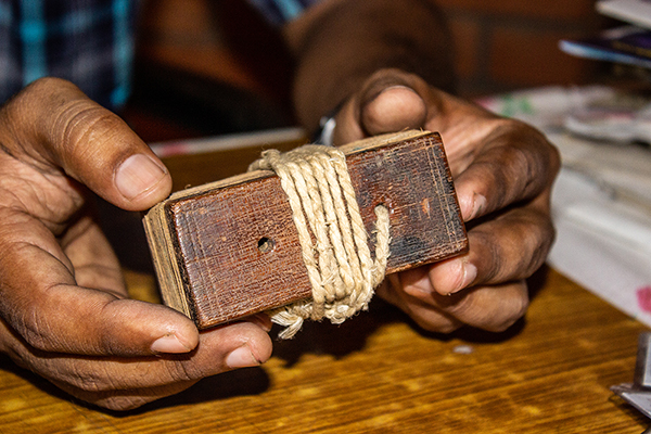 Man holding a bundle of manuscripts