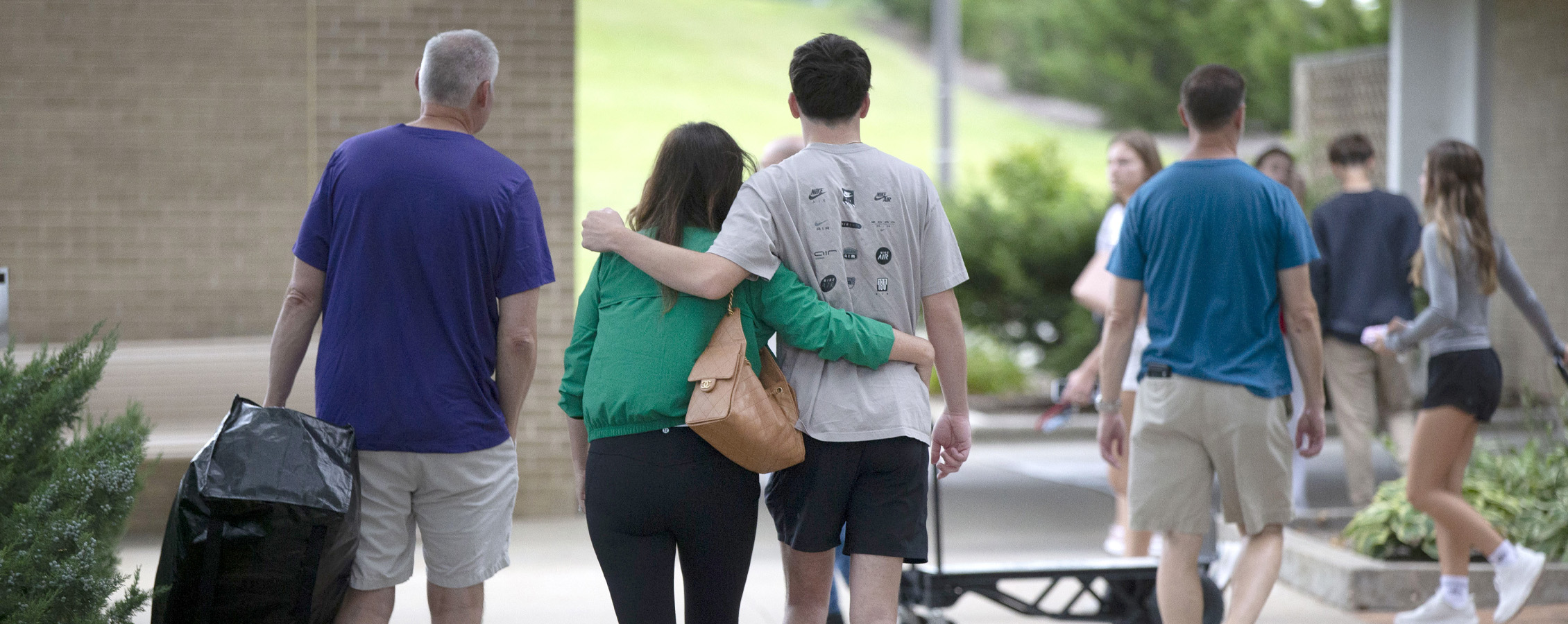 Parents walk arm in arm their student.