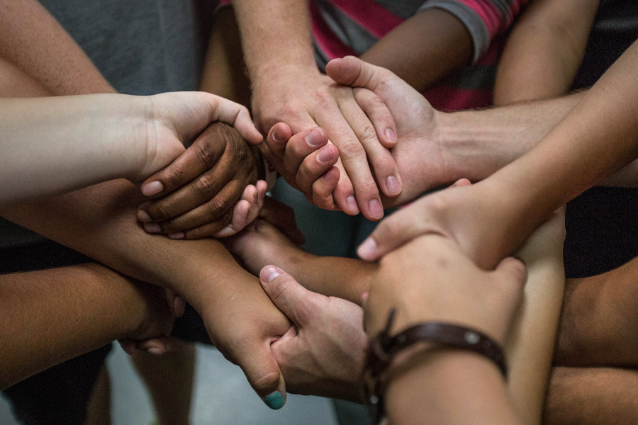 Hands of all sizes and colors hold hands.